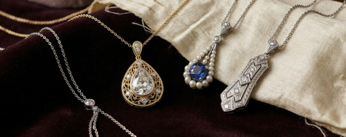 A selection of ornate antique necklaces displayed on luxurious velvet fabric.